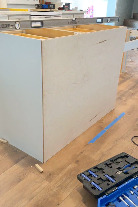 Adding paneling to the back of a kitchen island cabinet.